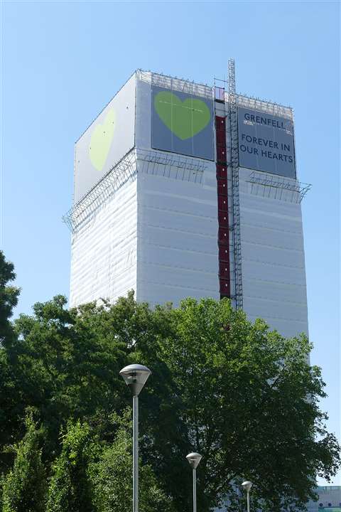 的形象Grenfell塔在2017年火,周围有白色和绿色囤积了阅读“Grenfell:永远在我们心中”。